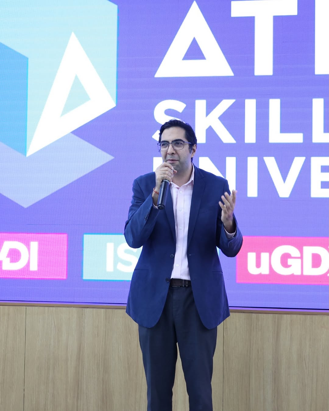 Photo by ATLAS SkillTech University on April 19, 2026. May be an image of one or more people, microphone and text that says "AT SKILI VIVE DII IS DI uGD".